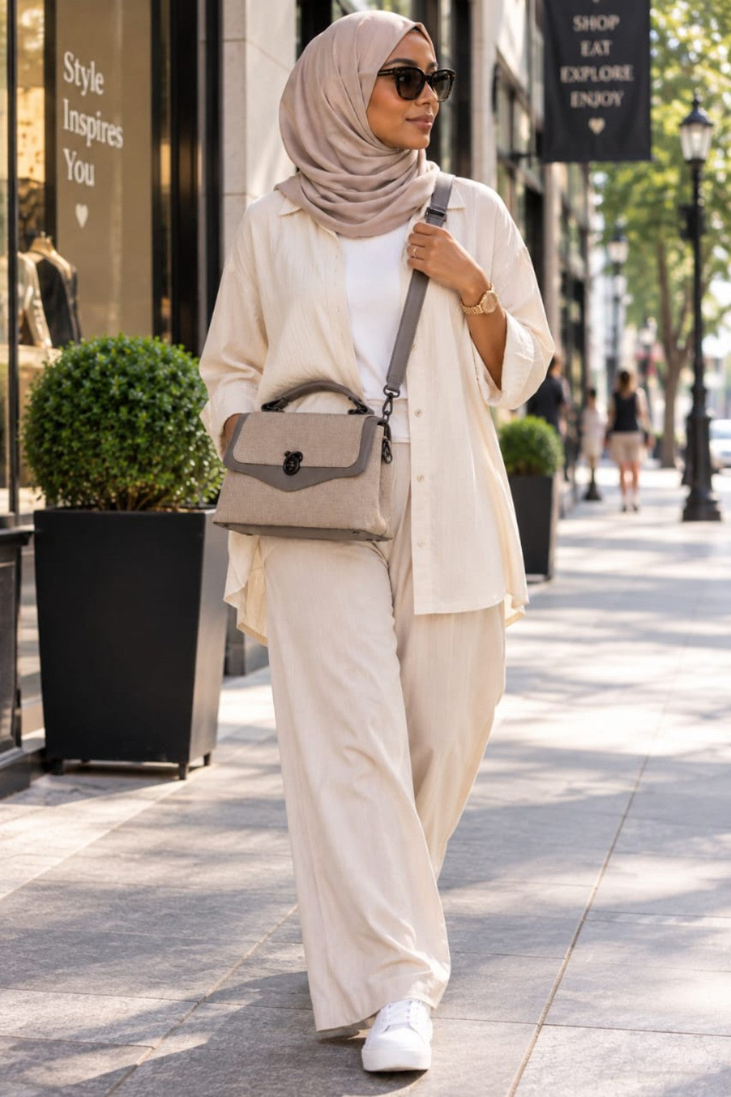 Sac QAZA taupe 25 cm porté en ville avec sa bandoulière